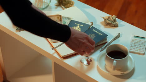 una mujer toma un pasaporte canadiense y un pasaporte estadounidense de la mesa de café