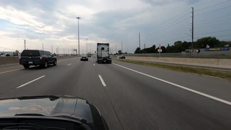 pov car: canadian highway with vehicles and overcast sky