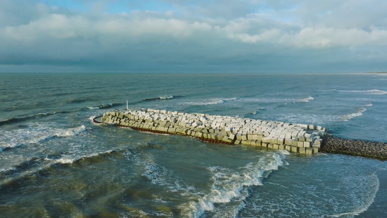 라트비아 리파자(liepaja)에 있는 발트해 연안에 콘크리트 블록과 바위가 있는 보호용 석조 부두의 공중 설정 전망, 해안 침식에 대비한 해변 강화, 드론이 아래로 기울어짐
