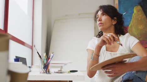 video of thoughtful biracial female artist in studio