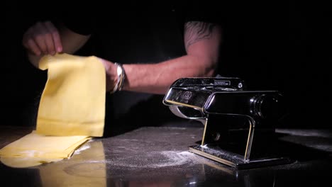 chef haciendo pasta tradicional usando una máquina para cortar masa en la cocina, cerrar