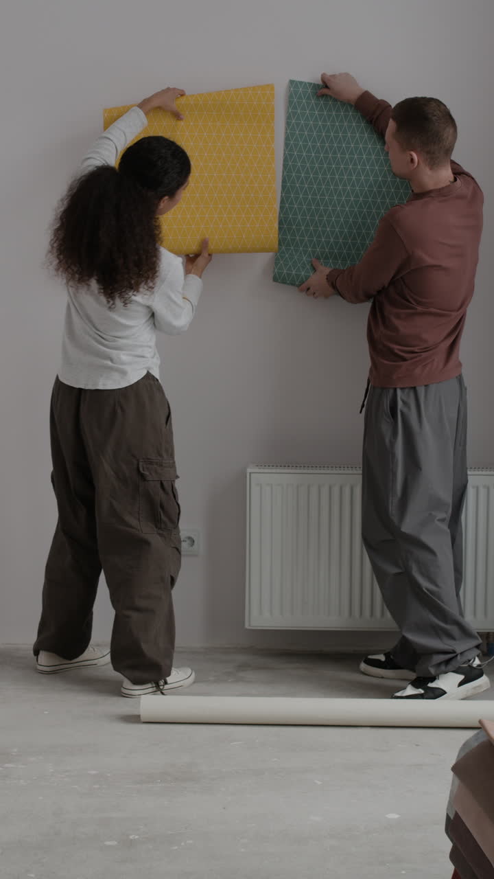 Young Couple Decorating Their New Home with Wallpaper