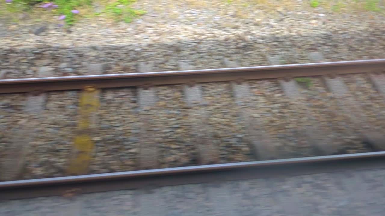 Railway Tracks Moving By As Train Departs Station and Heads to Destination. Public Transportation Footage on British Rail Network. Wooden Sleepers Supporting Hot Rolled Steel for Carriage to Ride On