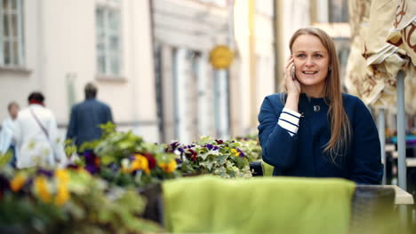 Young-woman-talking-on-the-phone-in-outdoor-cafe