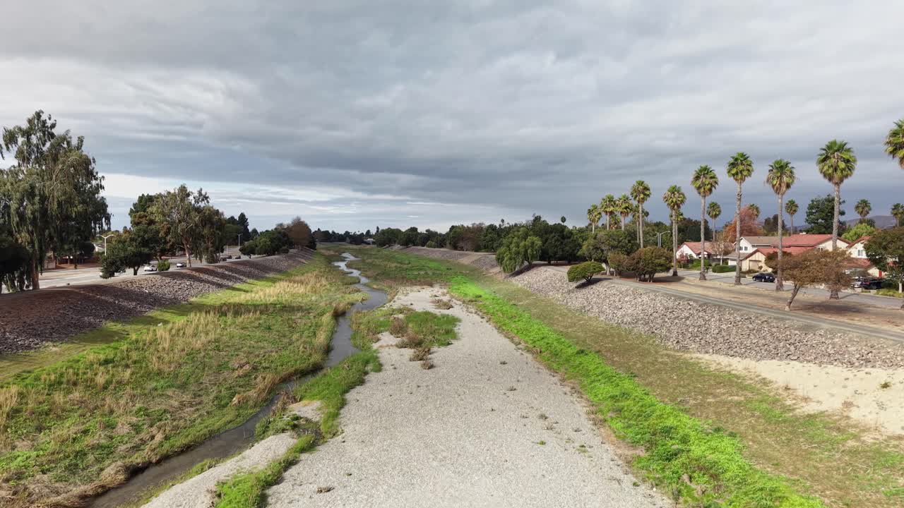 Drone push in above Alameda Creek Trail, revealing the winding waterway, open fields, and nearby Fremont neighborhoods, with quiet streets and parks forming a calm blend of nature and suburban life