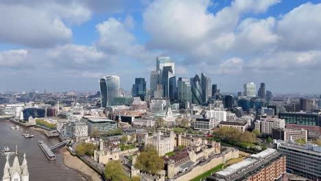 stunning drone footage captures an aerial approach to the city of london, with beautiful clouds in the background and a gleaming skyline of modern skyscrapers rising above historic architecture.