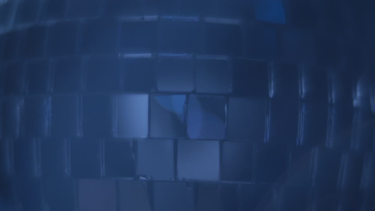 la luz azul que brilla sobre la pelota de la discoteca con humo que se eleva