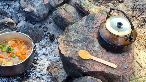 camping and cooking stew over a campfire