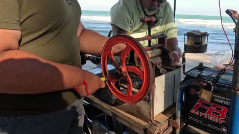 person turning a wheel to operate a machine