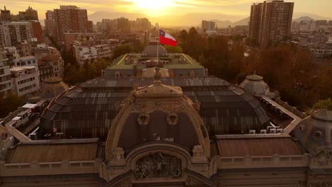 slow motion footage approaching chilean flag waving in air in city center at sunset, chile