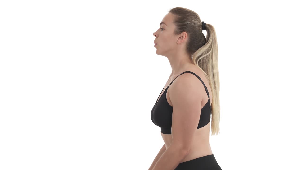 Side view portrait of biceps workout by blond sportswoman with resistance loop bands. Isolated on white background.