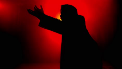 dramatic, stylistic, jesus christ kneeling and praying, worshipping in red glowing light for christianity, easter visual, bible scene or temptation, prayer, worship visual.