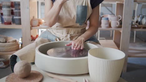 female potter prepares pottery wheel for further work.