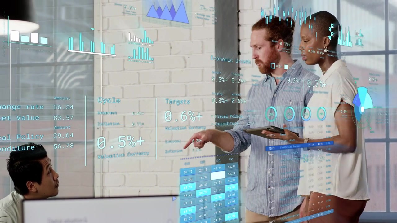 Standing colleagues tapping tablet, pointing at glass data overlays, aligning team on data plan