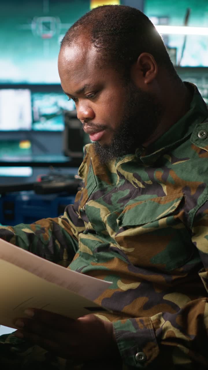 Vertical video Army specialist overseeing national safety operations, reading folder files
