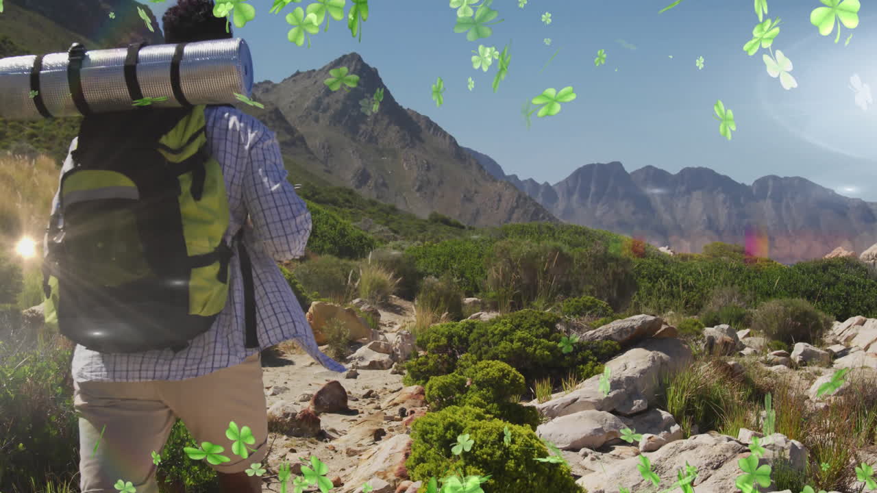 Hiker with backpack walking on mountain trail with clover animation overlay