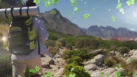 Hiker with backpack walking on mountain trail with clover animation overlay