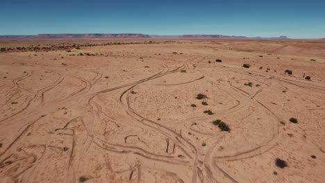 aerial view of a desert landscape with vehicle tracks