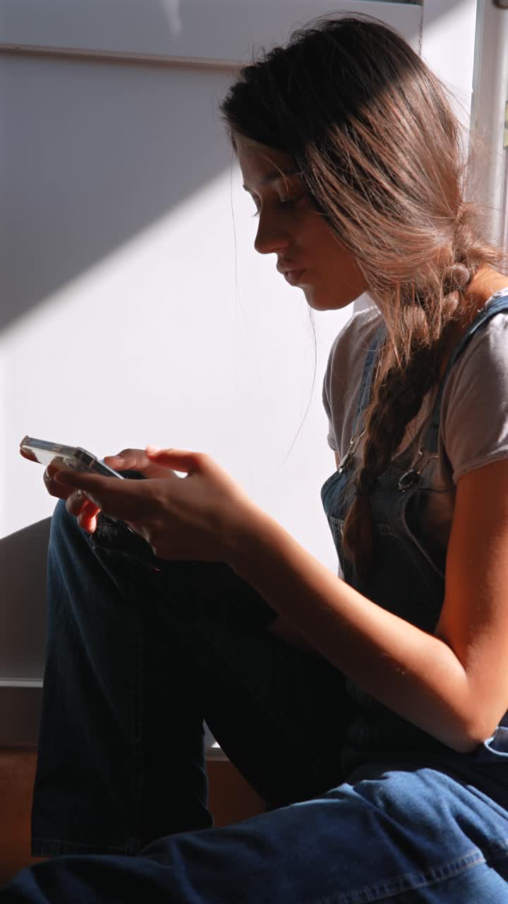 mujer joven sentada y usando un teléfono inteligente