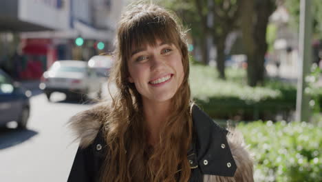 portrait of beautiful young woman smiling cheerful enjoying sunny urban day looking positive in city street background slow motion