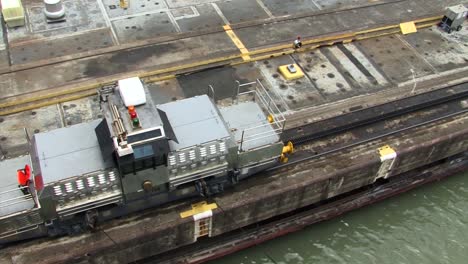 Locomotive-slowly-pulling-the-ship-thru-Pedro-Miguel-Locks,-Panama-Canal