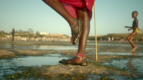 Piernas-De-Guerrero-Masai-Vigilando-Y-Parado-En-La-Playa-En-Watamu,-Kenia