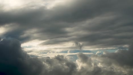 oscuras y dramáticas nubes en movimiento tomadas desde la ventana del avión con el sol escondido detrás de las nubes