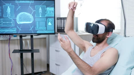 patient in a neuroscience centre wearing vr goggle and making hand gestures