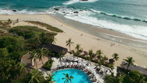 hermoso club de playa rodeado de palmeras con vista a una playa de arena blanca en oaxaca mexico