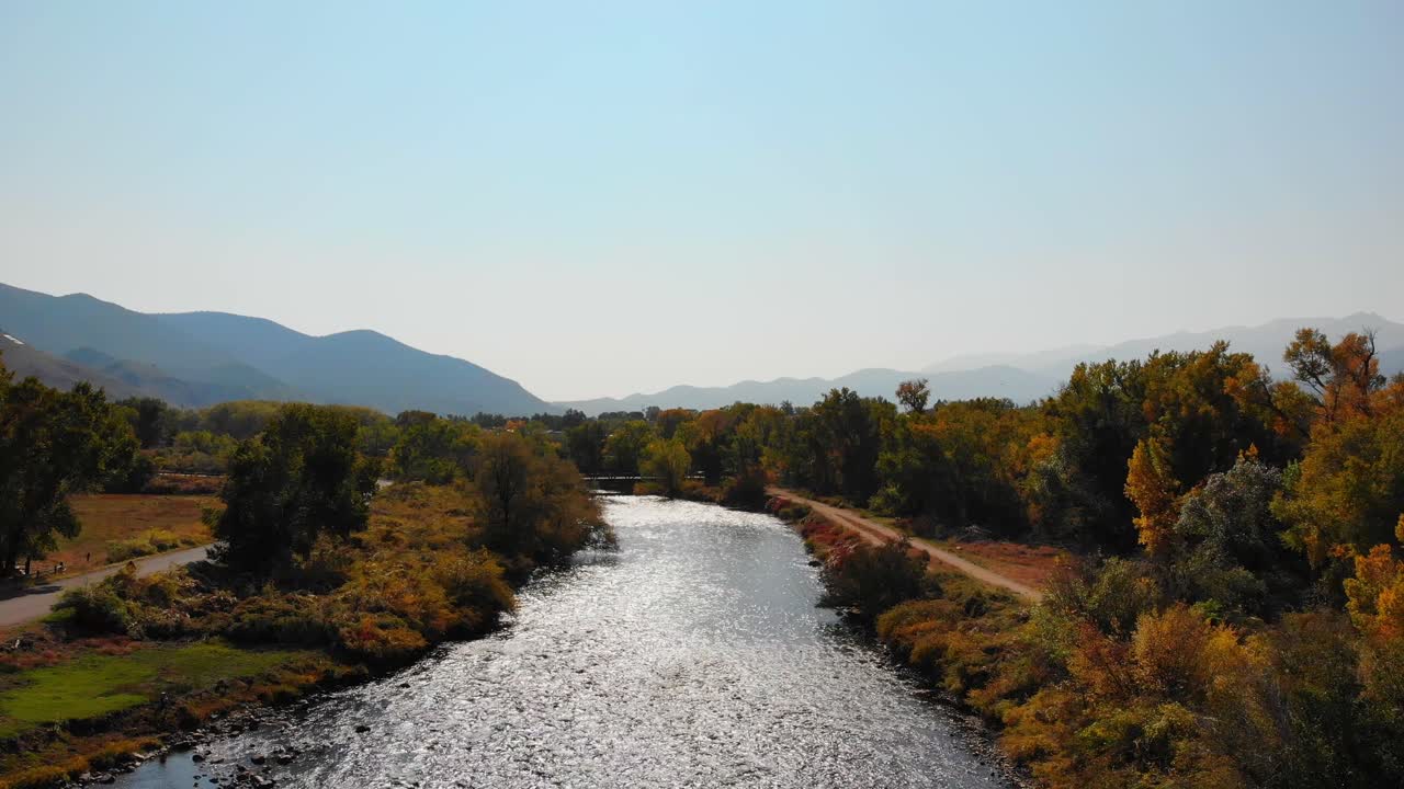 río de otoño que fluye en un valle montañoso con un exuberante follaje amarillo cerca de las montañas rocosas, colorado, ee.uu.
