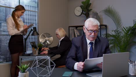 senior company manager laughing looking and pointing at camera ridiculous appearance, joke from you