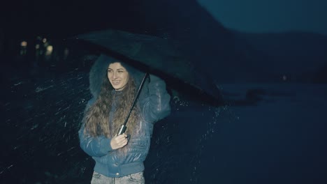 Fröhliches-Mädchen-Springt-Mit-Regenschirm-Unter-Frühlingsregen-In-Der-Nacht