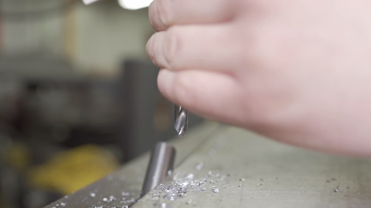 금속 세공인은 산업용 금속 제조 공장에서 드릴 비트를 변경합니다.