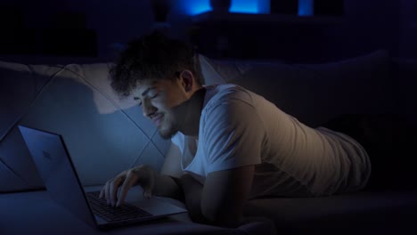 cheerful young man using laptop.