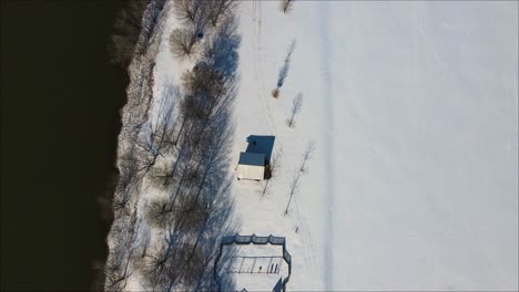 A-playground-in-the-snow-along-the-river,-during-a-winter-snow