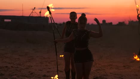 professional dancers women make a fire show and pyrotechnic performance at the festival with burning sparkling torches.