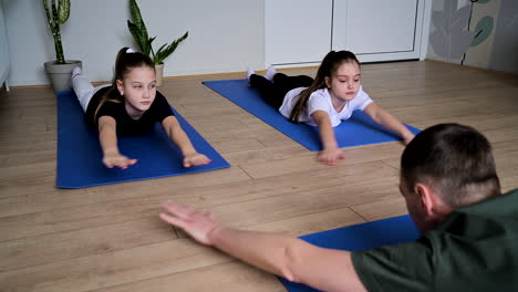 hombre y niños haciendo ejercicio en clase