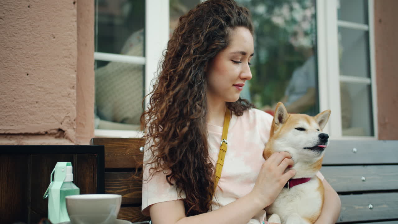 Woman with Curly Hair and Shiba Inu Dog at an Outdoor Cafe