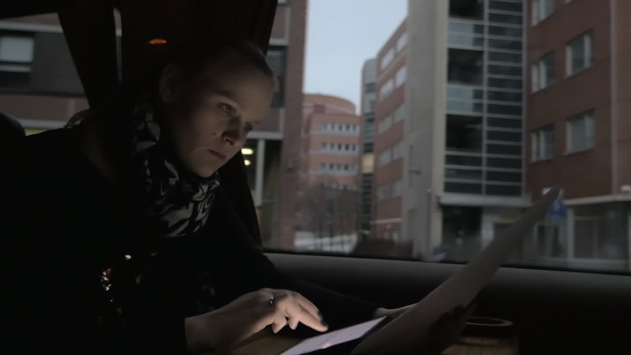 Donna d'affari che lavora con un tablet digitale e documenti in treno