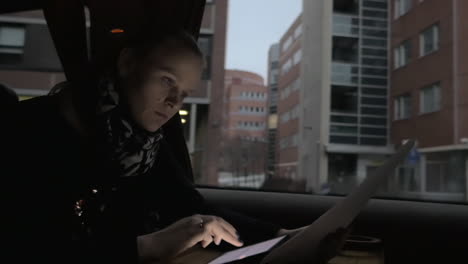 Businesswoman-working-with-digital-tablet-and-documents-in-train