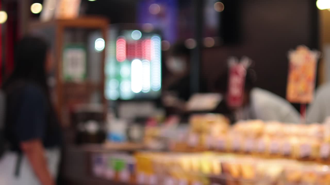 คนสองคนกำลังสนทนากันที่เคาน์เตอร์ร้านเบเกอรี่