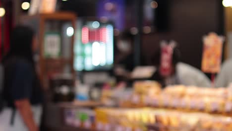 two people conversing over a bakery counter