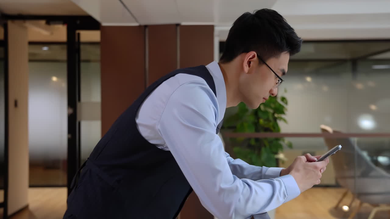 ビジネスライフスタイル。自信に満ちた若いビジネスマンがロビーで携帯電話を使用。屋内で座りながらスマートフォンを操作する男性の手。ガジェットでオンラインを閲覧し、携帯電話でテキストメッセージを打つ指。