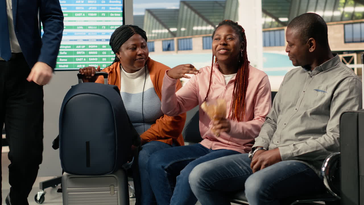 Happy family passengers in good mood traveling together in busy airport