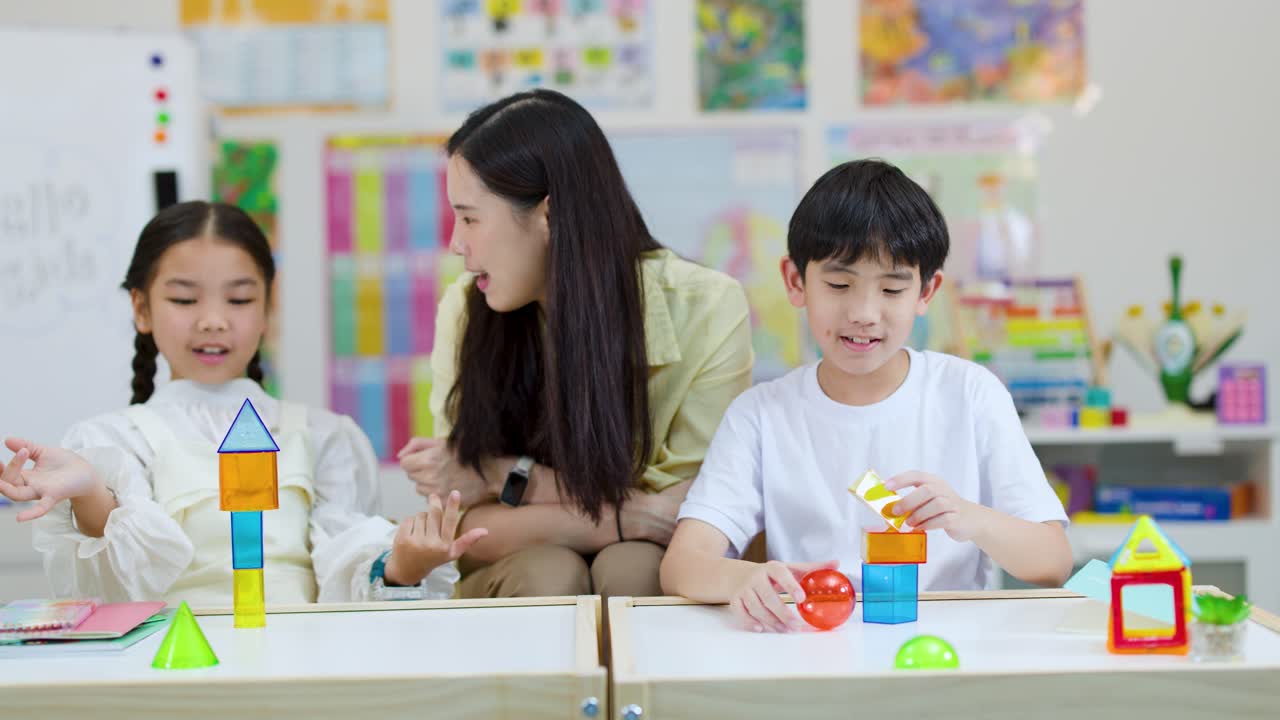明るく楽しい教室で、子供と先生が交流し、カラフルなブロックを一緒に組み立てています。