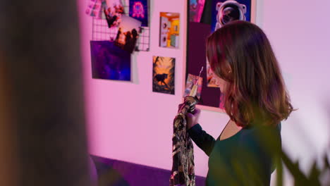 woman examining a sequined dress in a stylish room