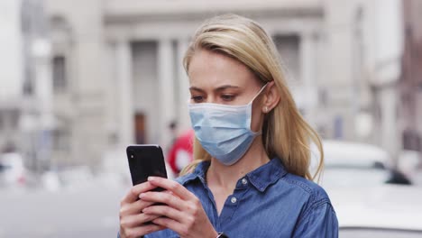 side view caucasian woman wearing a coronavirus covid19 mask and using her phone