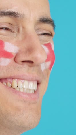 happy man with english flag painted on face looking away