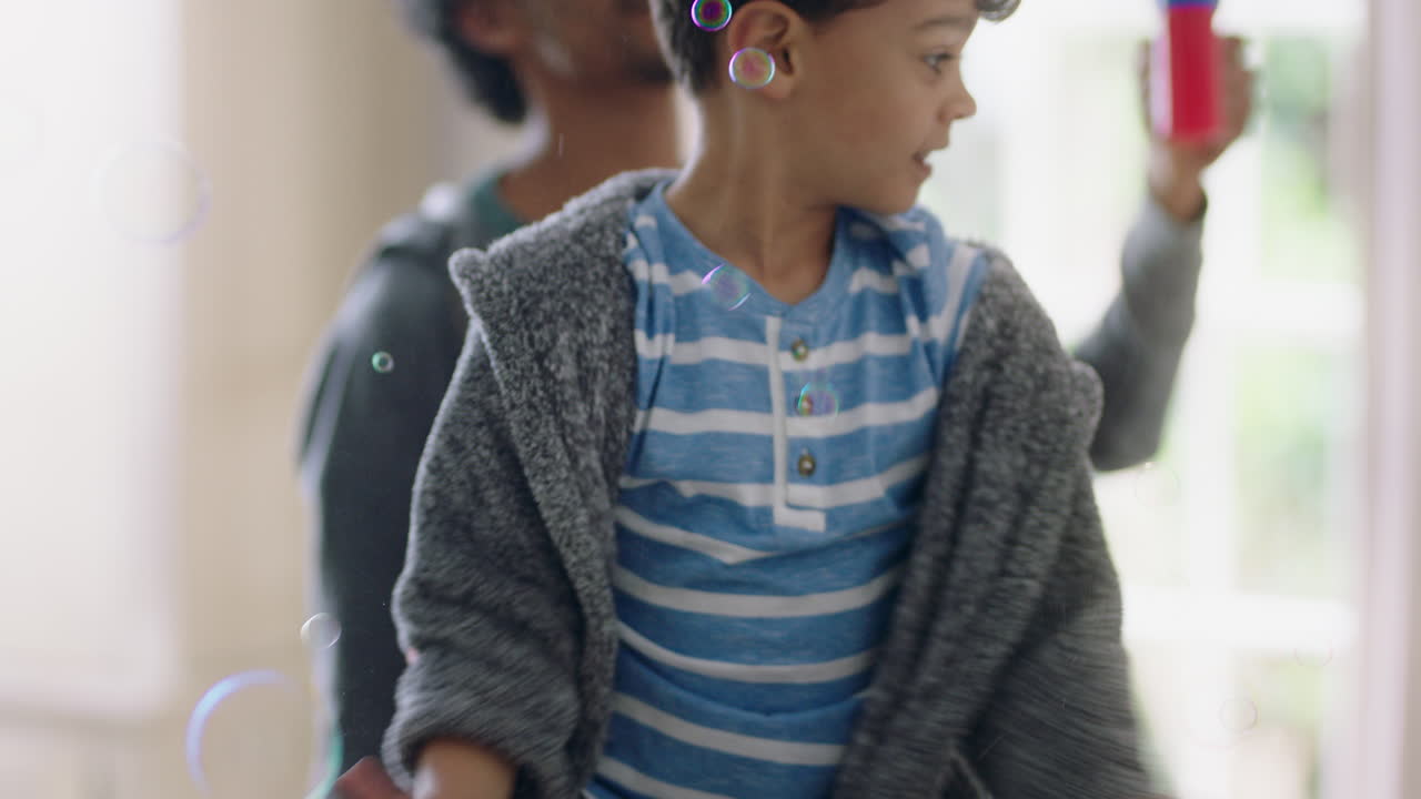 귀여운 작은 소년이 집에서 비누 거품으로 놀고 엄마와 아빠가 집에서 아이와 함께 즐기고 주말에 가족 시간을 즐기고 있습니다.