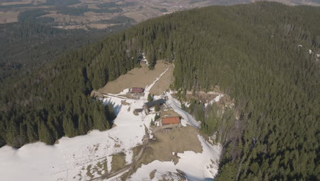 aerial 5k birdseye drone over snowy mountainside and pine forest in german alps